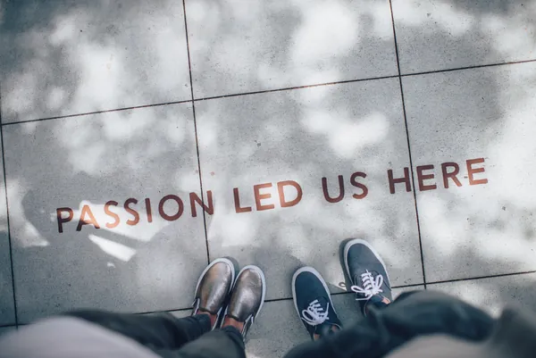 Schuhe auf Pflaster mit dem Schriftzug Passion led us here