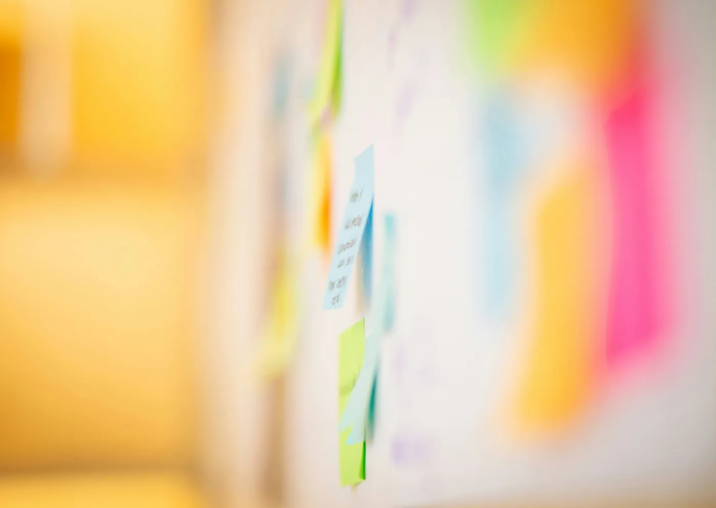 Bunte Haftnotizen an einer Wand in einem moderierten Workshop
